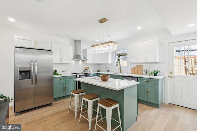 1232 S Bucknell St, Philadelphia, PA 19146 - kitchen with stainless steel appliances, wall chimney exhaust hood, green cabinets, light wood-style floors, and recessed lighting