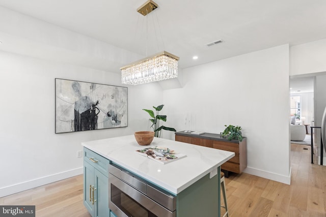 1232 S Bucknell St, Philadelphia, PA 19146 - kitchen featuring light wood finished floors, a chandelier, light countertops, a center island, and pendant lighting