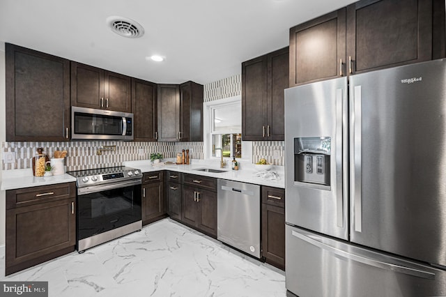 9017 Marcella Ave, Randallstown, MD 21133 - kitchen with appliances with stainless steel finishes, dark brown cabinetry, light countertops, light marble finish flooring, and recessed lighting