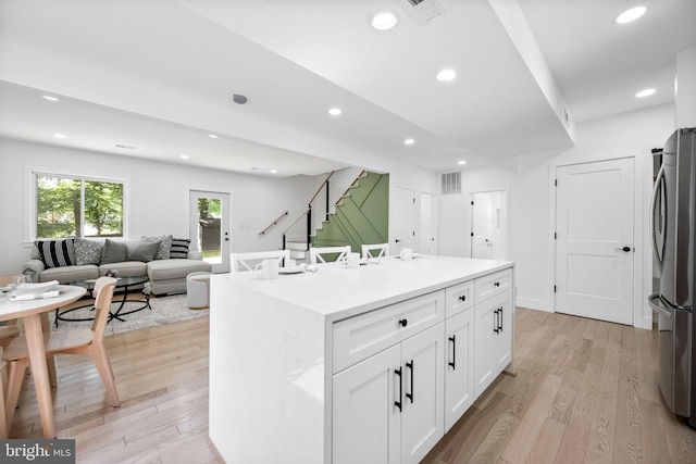 7214 16th Ave, Takoma Park, MD 20912 - kitchen with freestanding refrigerator, white cabinetry, light wood-style flooring, recessed lighting, and a kitchen island