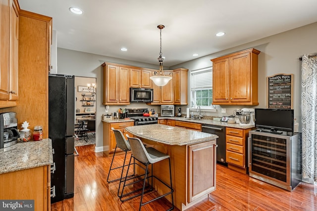 15 Boraten Cir, Royersford, PA 19468 - kitchen with black appliances, wine cooler, light wood finished floors, a kitchen bar, and recessed lighting