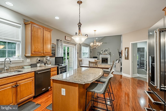 15 Boraten Cir, Royersford, PA 19468 - kitchen featuring dishwasher, wood finished floors, a kitchen island, brown cabinetry, and light stone counters