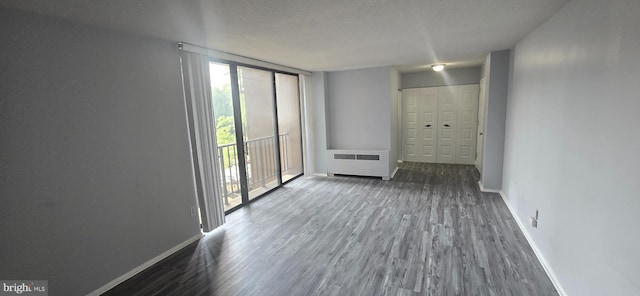 6100 Westchester Park Dr Unit 520, College Park, MD 20740 - spare room with radiator heating unit, wood finished floors, and a textured ceiling