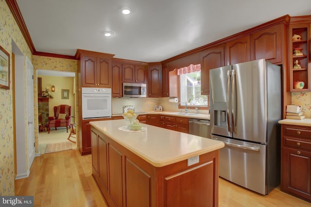 11733 Woodlea Dr, Waynesboro, PA 17268 - kitchen featuring stainless steel appliances, wallpapered walls, ornamental molding, light wood-style floors, and light countertops