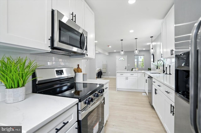 2011 Englewood Ave, Baltimore, MD 21207 - kitchen with appliances with stainless steel finishes, recessed lighting, a peninsula, white cabinets, and tasteful backsplash