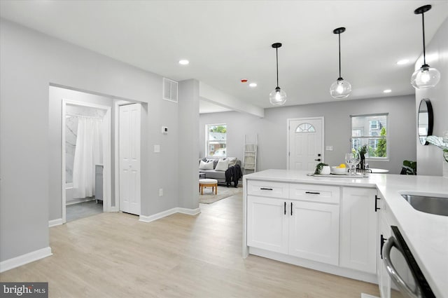 2011 Englewood Ave, Baltimore, MD 21207 - kitchen featuring dishwasher, light wood finished floors, recessed lighting, white cabinetry, and light countertops