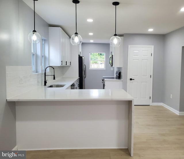 2011 Englewood Ave, Baltimore, MD 21207 - kitchen with stainless steel appliances, white cabinetry, light wood-type flooring, light countertops, and recessed lighting