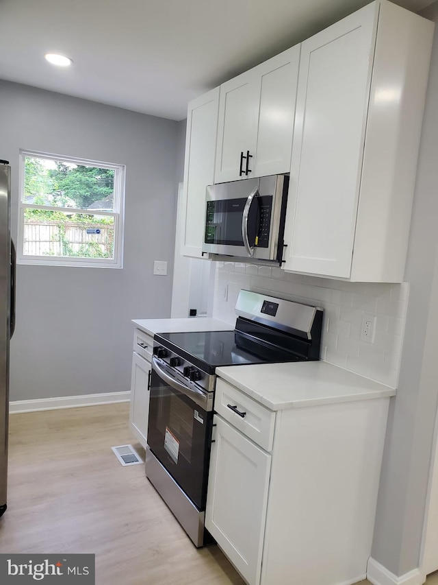 2011 Englewood Ave, Baltimore, MD 21207 - kitchen with stainless steel appliances, decorative backsplash, light countertops, light wood finished floors, and recessed lighting