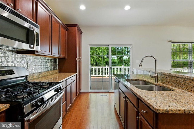7003 Dannfield Ct, Glen Burnie, MD 21060 - kitchen featuring appliances with stainless steel finishes, light wood-style flooring, tasteful backsplash, recessed lighting, and light stone counters