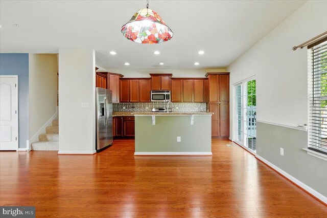 7003 Dannfield Ct, Glen Burnie, MD 21060 - kitchen featuring appliances with stainless steel finishes, wood finished floors, backsplash, a kitchen breakfast bar, and recessed lighting