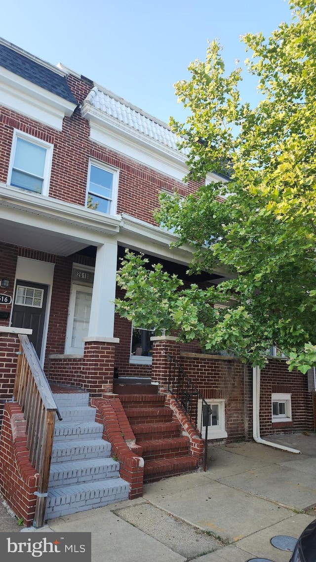 2618 E Biddle St, Baltimore, MD 21213 - view of front of home with brick siding, covered porch, and mansard roof