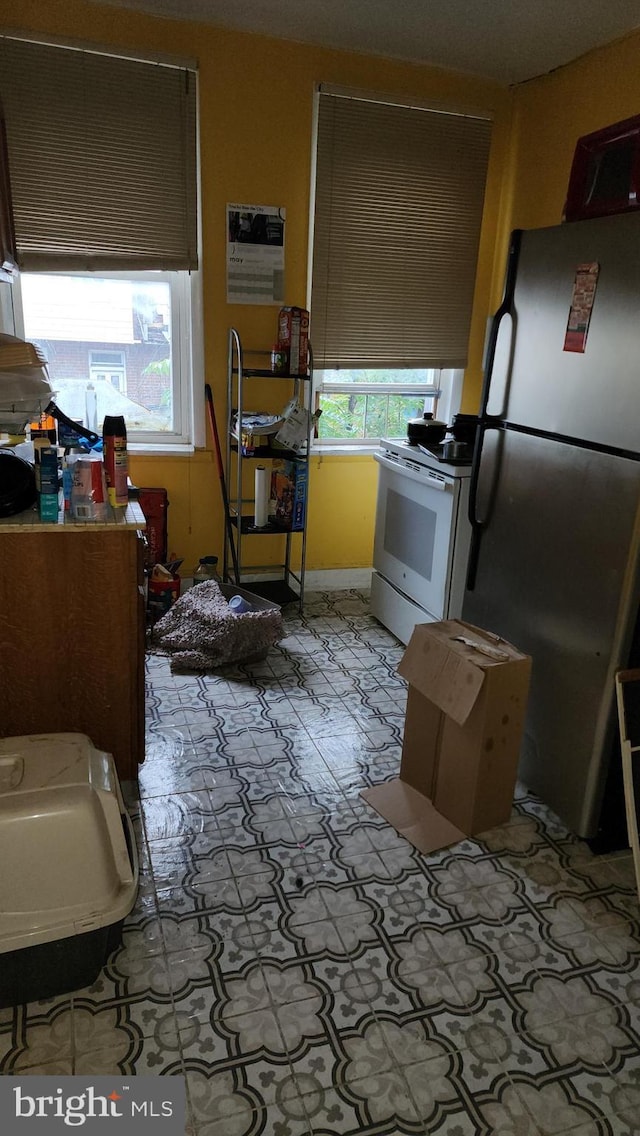 2618 E Biddle St, Baltimore, MD 21213 - kitchen featuring freestanding refrigerator, white electric stove, and plenty of natural light