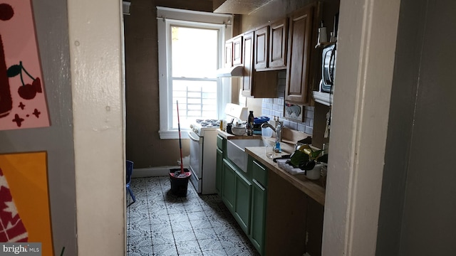 2618 E Biddle St, Baltimore, MD 21213 - kitchen featuring white gas range oven, under cabinet range hood, an office area, and light countertops