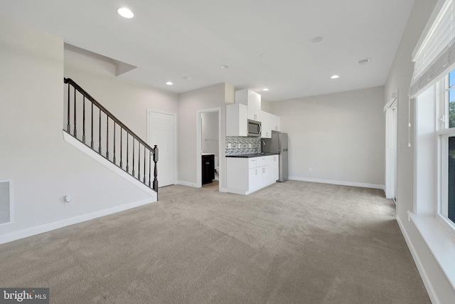 42510 Oak Park Sq, Ashburn, VA 20148 - unfurnished living room with light carpet, stairway, and recessed lighting