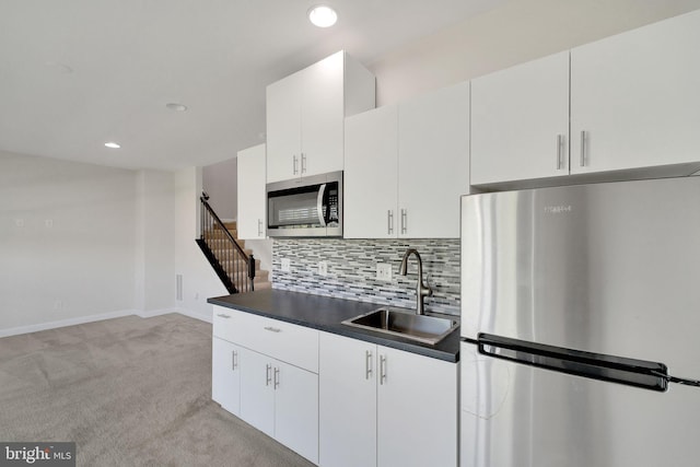 42510 Oak Park Sq, Ashburn, VA 20148 - kitchen featuring stainless steel appliances, light colored carpet, tasteful backsplash, recessed lighting, and white cabinetry