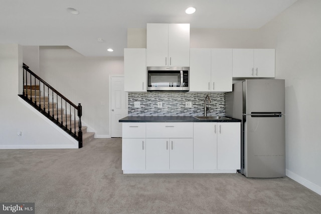 42510 Oak Park Sq, Ashburn, VA 20148 - kitchen with appliances with stainless steel finishes, light colored carpet, white cabinets, dark countertops, and recessed lighting