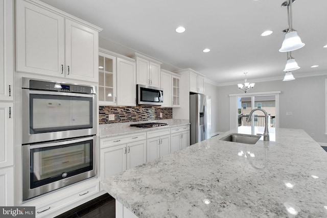 42510 Oak Park Sq, Ashburn, VA 20148 - kitchen featuring stainless steel appliances, white cabinets, a chandelier, ornamental molding, and glass insert cabinets