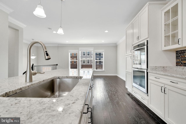 42510 Oak Park Sq, Ashburn, VA 20148 - kitchen featuring stainless steel double oven, ornamental molding, dark wood-style floors, glass insert cabinets, and white cabinets