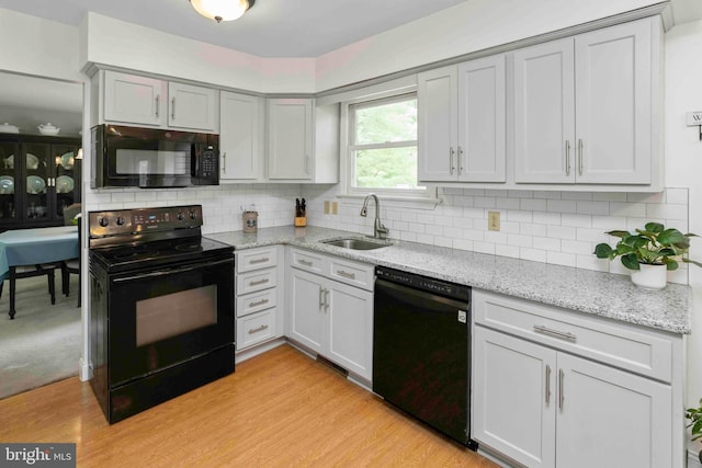 125 Christine Dr, Downingtown, PA 19335 - kitchen featuring black appliances, decorative backsplash, light stone countertops, and light wood-style floors