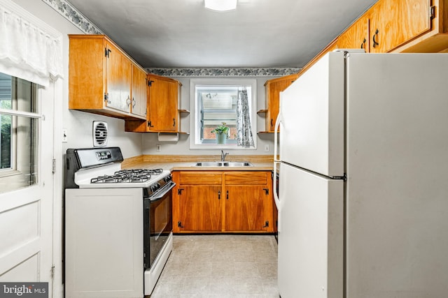 73 Duncan Ln, Springfield, PA 19064 - kitchen featuring freestanding refrigerator, range with gas cooktop, light countertops, and brown cabinetry