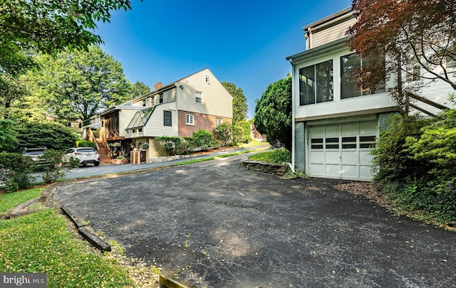73 Duncan Ln, Springfield, PA 19064 - view of side of home with an attached garage and asphalt driveway