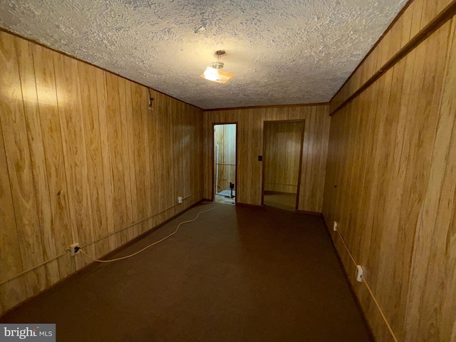 2133 Freda Dr, Vienna, VA 22181 - unfurnished room featuring a textured ceiling, wooden walls, and dark carpet