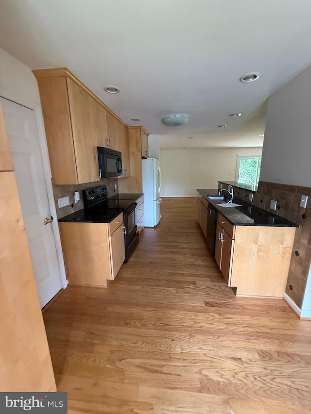 2133 Freda Dr, Vienna, VA 22181 - kitchen with black appliances, light wood finished floors, light brown cabinetry, dark countertops, and tasteful backsplash