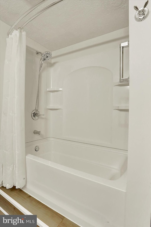 183 Mill Rd, Chambersburg, PA 17201 - full bath featuring a textured ceiling, shower / tub combo with curtain, and wood finished floors
