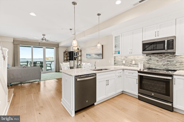 220 25th St Unit D, Ocean City, MD 21842 - kitchen featuring appliances with stainless steel finishes, open floor plan, decorative backsplash, white cabinets, and a peninsula