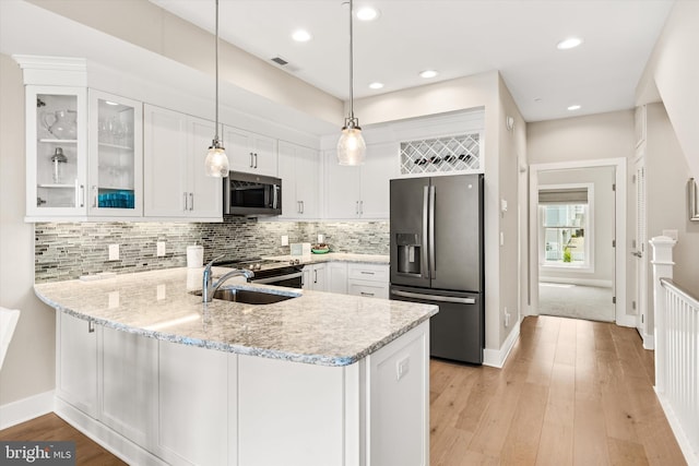 220 25th St Unit D, Ocean City, MD 21842 - kitchen with stainless steel appliances, a peninsula, white cabinets, glass insert cabinets, and light stone counters