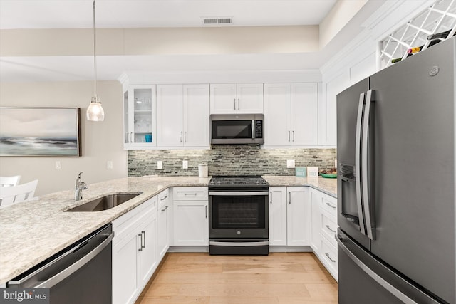 220 25th St Unit D, Ocean City, MD 21842 - kitchen with stainless steel appliances, backsplash, white cabinetry, light wood-style flooring, and glass insert cabinets