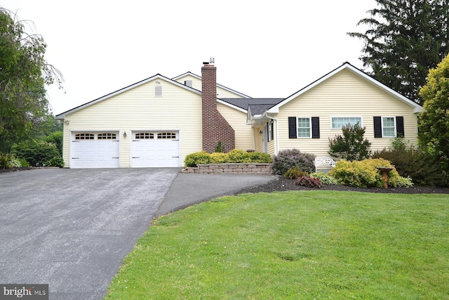 146 Skyline Dr, New Holland, PA 17557 - view of front of property with asphalt driveway, a chimney, an attached garage, and a front yard