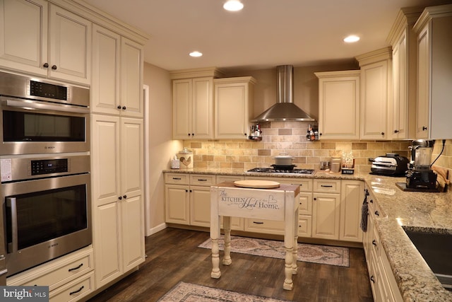 146 Skyline Dr, New Holland, PA 17557 - kitchen featuring wall chimney exhaust hood, stainless steel double oven, gas stovetop, dark wood-style flooring, and decorative backsplash