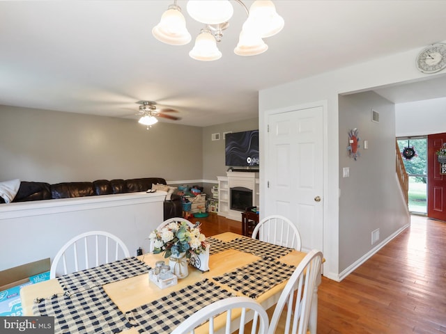 6 Thompson Ct, Boonsboro, MD 21713 - dining space featuring a chandelier, wood finished floors, a ceiling fan, and a fireplace