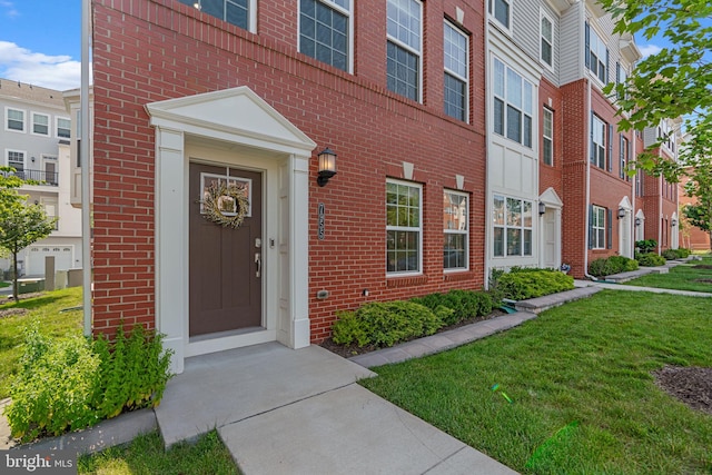 7955 Blue Stream Dr, Elkridge, MD 21075 - view of exterior entry featuring brick siding, a yard, and a residential view