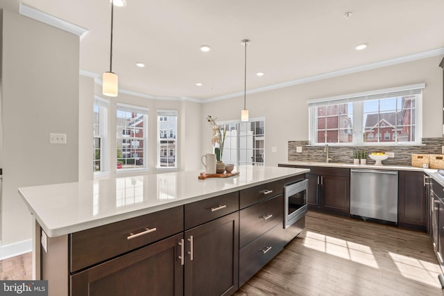 7955 Blue Stream Dr, Elkridge, MD 21075 - kitchen featuring stainless steel appliances, decorative backsplash, light countertops, light wood finished floors, and healthy amount of natural light