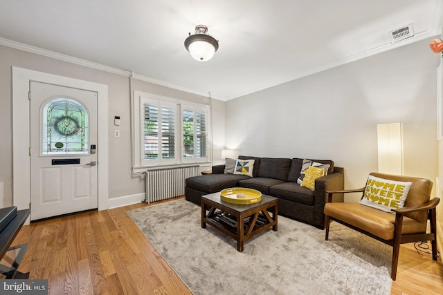 636 N Alfred St, Alexandria, VA 22314 - living room featuring radiator, ornamental molding, and light wood finished floors
