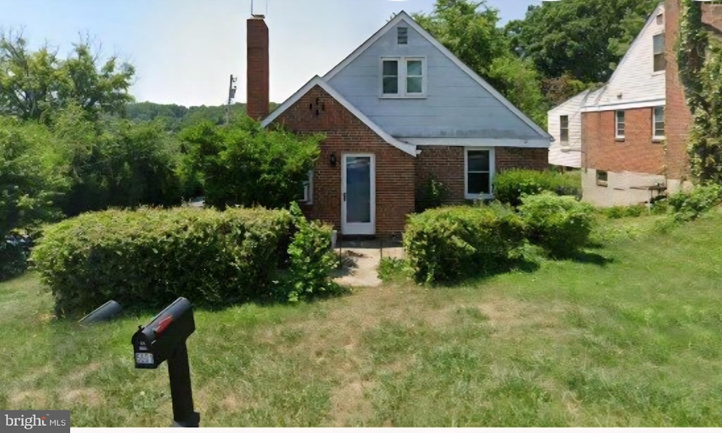 5601 Windsor Ml, Baltimore, MD 21207 - view of front facade with a chimney, brick siding, and a front yard