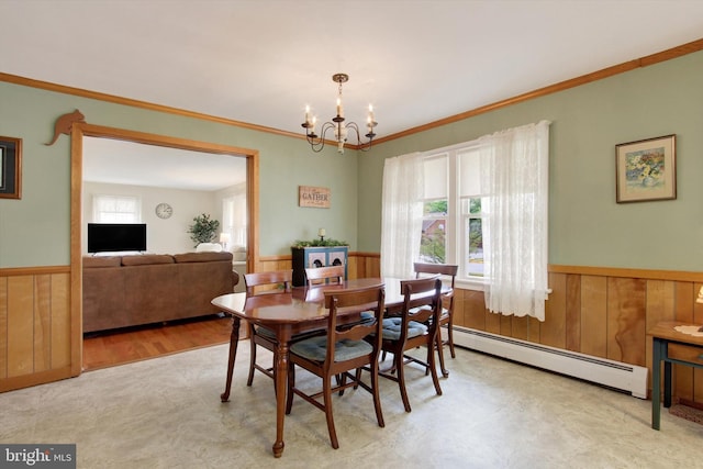 401 Jacobs St, East Berlin, PA 17316 - dining room with a baseboard heating unit, a wainscoted wall, a chandelier, wooden walls, and crown molding