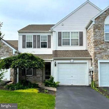 621 Springhouse Ln, Hummelstown, PA 17036 - view of front facade with stone siding, an attached garage, driveway, and roof with shingles