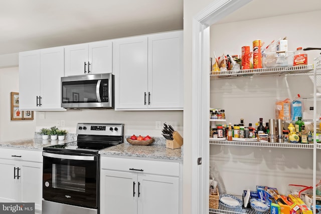 9 American Ave, Carlisle, PA 17013 - kitchen with stainless steel appliances, white cabinetry, and light stone countertops