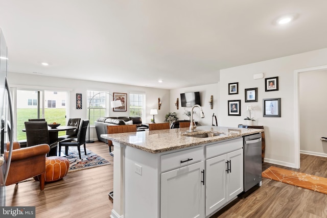 9 American Ave, Carlisle, PA 17013 - kitchen with stainless steel dishwasher, light wood-style flooring, a kitchen island with sink, open floor plan, and light stone counters