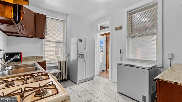 312 N 2nd St, Steelton, PA 17113 - kitchen with white appliances, radiator, light marble finish floors, light countertops, and dark brown cabinetry