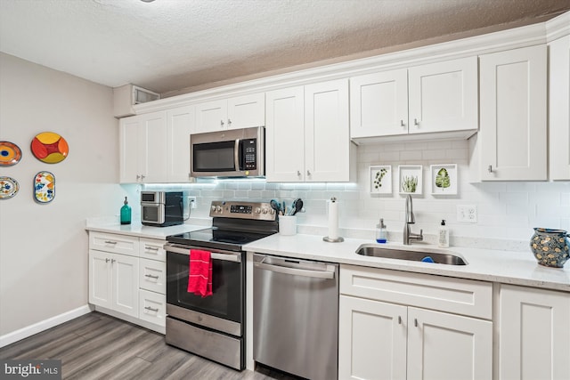 8370 Greensboro Dr Unit 1011, Mclean, VA 22102 - kitchen featuring appliances with stainless steel finishes, backsplash, light wood-type flooring, white cabinetry, and light countertops