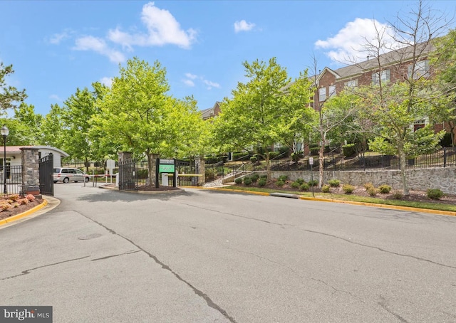 15196 Lancashire Dr, Woodbridge, VA 22191 - view of asphalt road with a gate, curbs, a gated entry, and street lighting