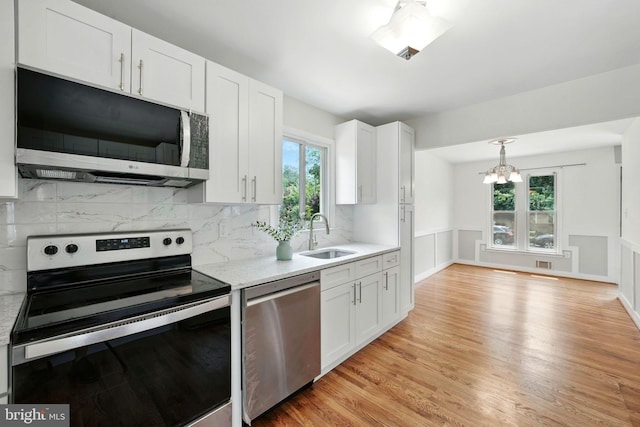 1418 D St, Woodbridge, VA 22191 - kitchen featuring stainless steel appliances, a chandelier, white cabinetry, healthy amount of natural light, and a wainscoted wall