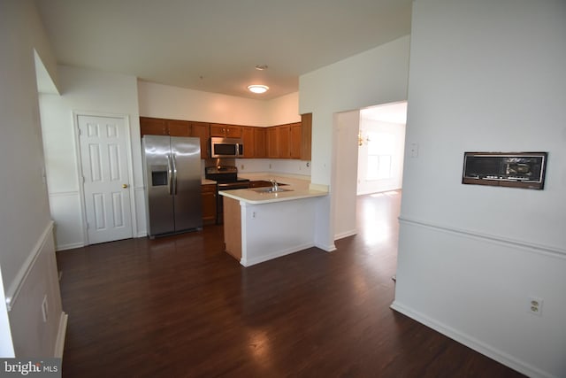 104 Rock Creek Ct, Frederick, MD 21702 - kitchen featuring stainless steel appliances, brown cabinets, a peninsula, dark wood-type flooring, and light countertops