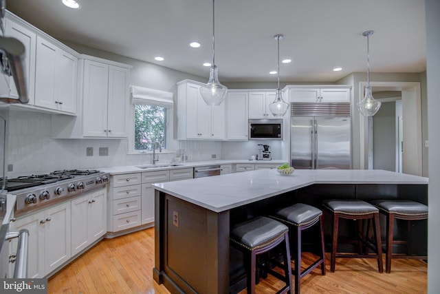 22966 Lois, Brambleton, VA 20148 - kitchen with built in appliances, white cabinetry, a breakfast bar area, decorative backsplash, and recessed lighting