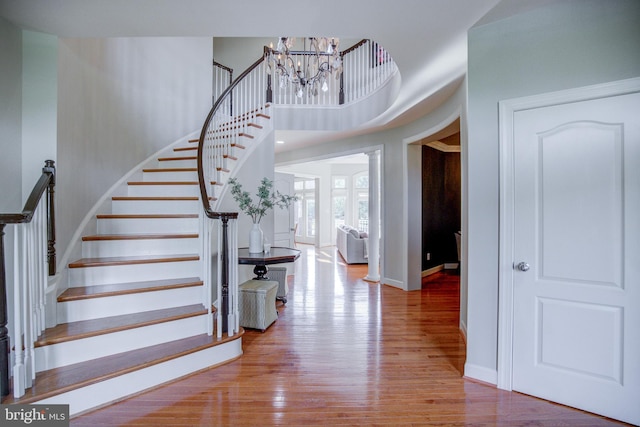 22966 Lois, Brambleton, VA 20148 - entrance foyer featuring wood finished floors, a chandelier, stairs, ornate columns, and a high ceiling