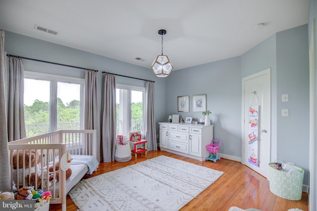 22966 Lois, Brambleton, VA 20148 - bedroom featuring light wood-type flooring and a nursery area